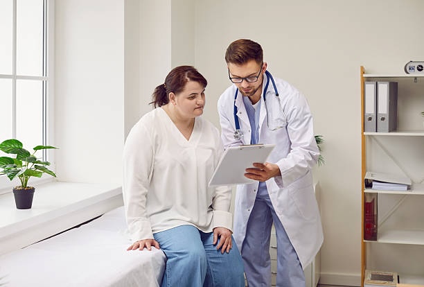 Doctor showing a chart to a patient during a supportive consultation in a bright medical office.