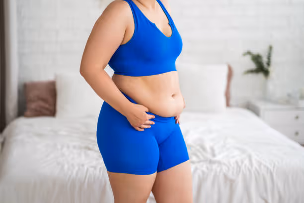 Woman with belly fat in blue workout clothes