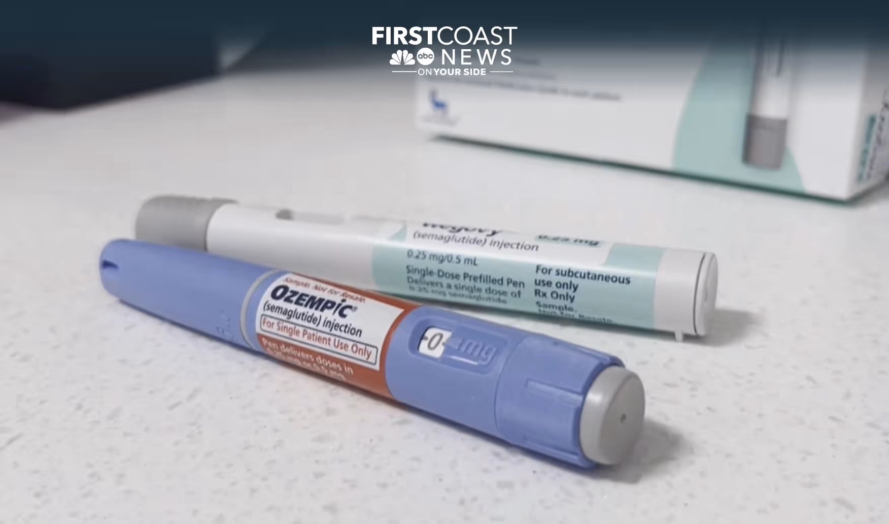 Two Ozempic pens next to their box and dose cartridges