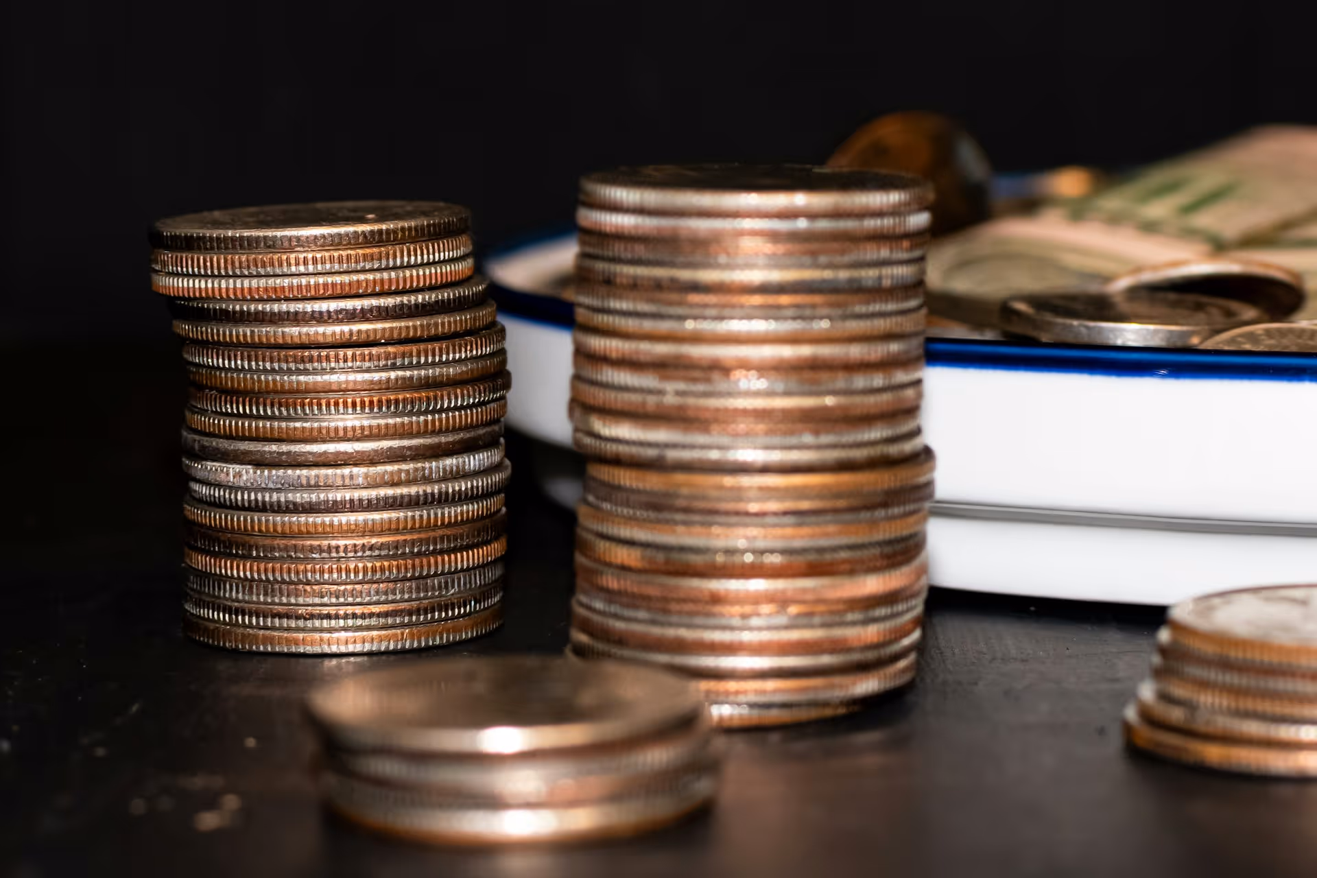 Two stacks of quarters in front of a blue and white plate